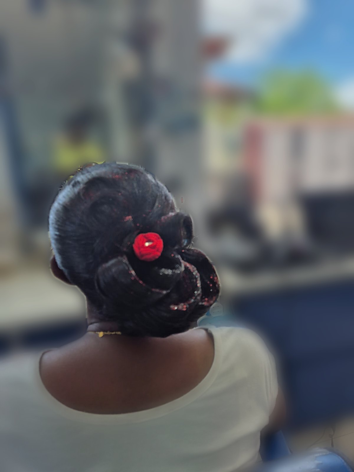 Chignon glamour orné d'une fleur rouge
