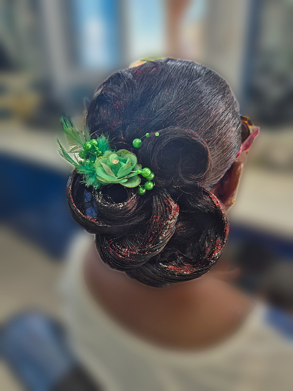 Chignon élégant orné d'une fleur, coiffure d'événement en Guadeloupe